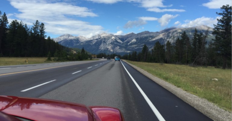 Car driving towards mountains